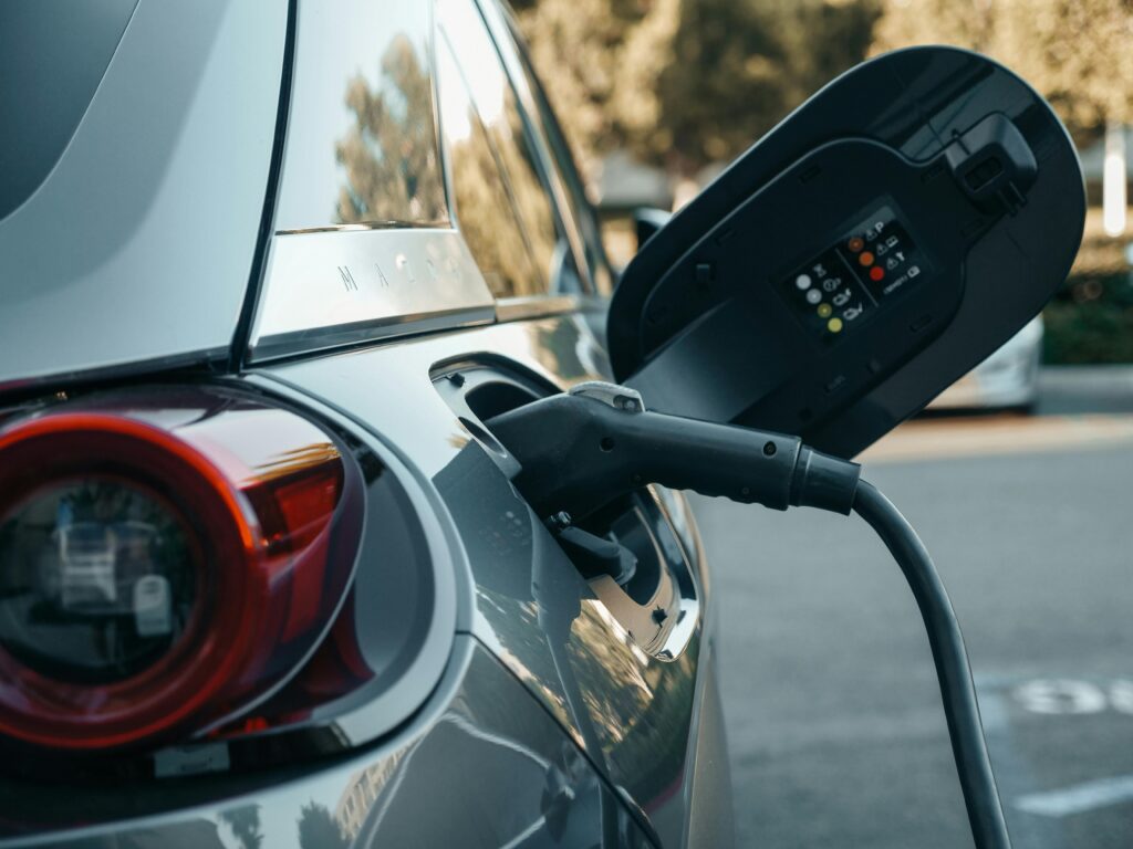 Close-up of an electric vehicle being charged, highlighting modern clean energy technology.