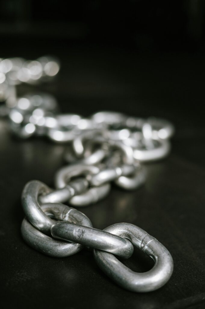 A chain of silver links on a black surface