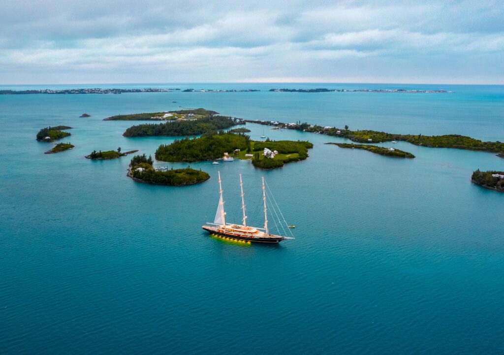 Stunning aerial view of a yacht sailing amidst the scenic islands and azure waters of Bermuda.